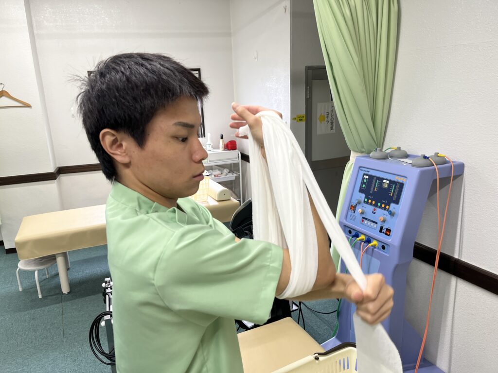 包帯を束ねる大分ごとう整骨院の柔道整復師・藤澤琉人先生